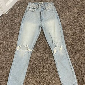 Abercrombie light wash mom jeans with rips on both legs.